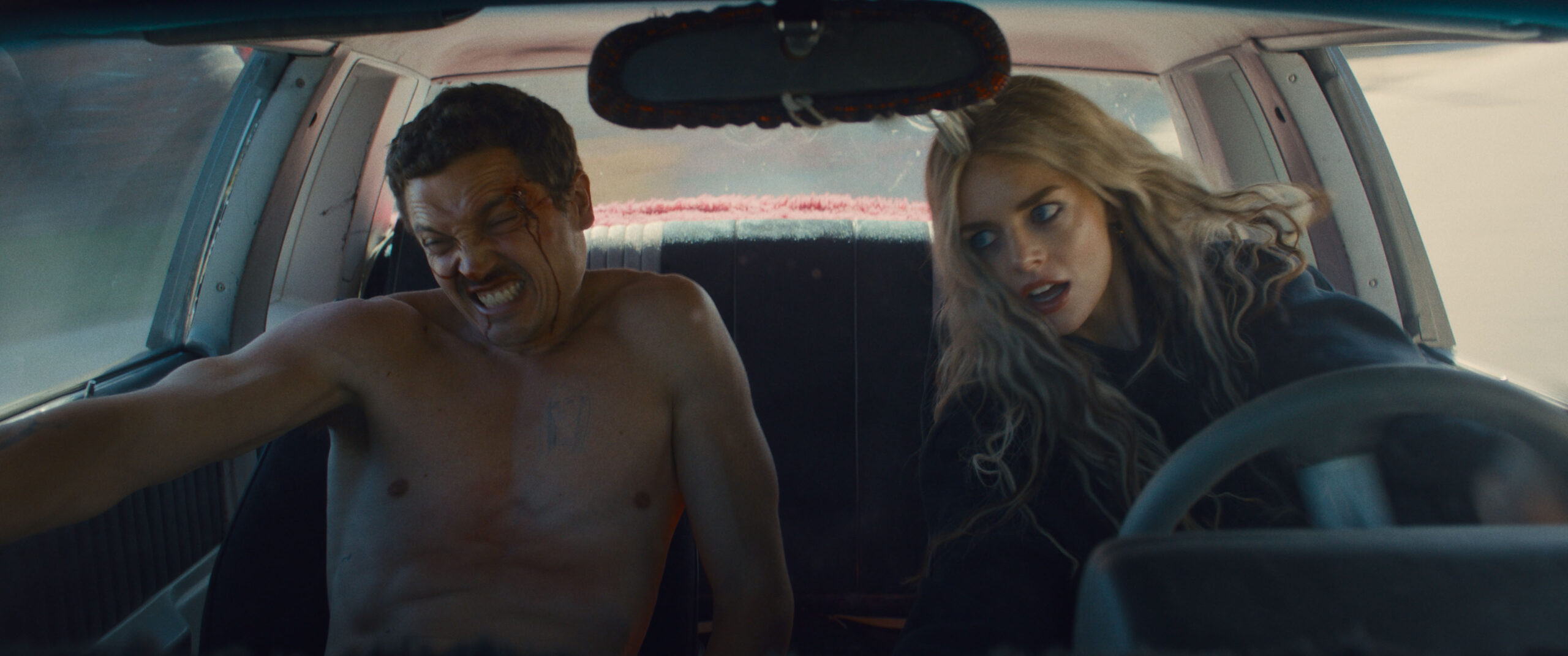 (L-R) Karl Glusman as John and Samara Weaving as Edie in 20th Century Studios' EENIE MEANIE. Photo courtesy of 20th Century Studios. © 2025 20th Century Studios. All Rights Reserved.